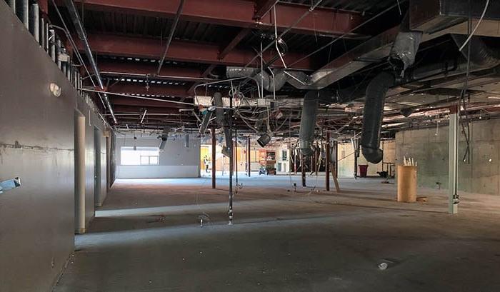 inside of a large room with ceiling tiles removed and wires hanging down