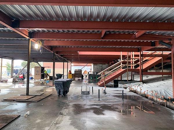 concrete floor under steel beams with metal over them; stairway up to the left