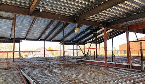 a room under construction with a metal roof and metal floor that has rebar across it