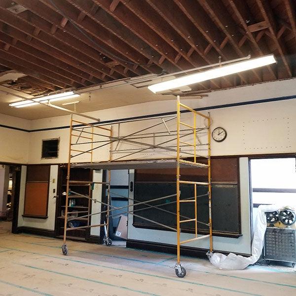 a classroom with no ceiling panels and a scaffolding