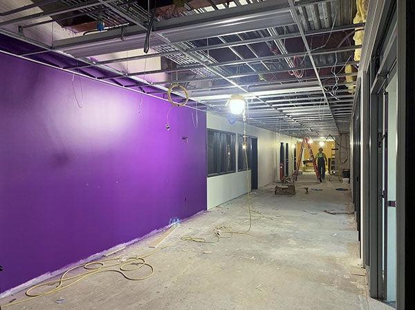 a purple wall in a hallway under construction