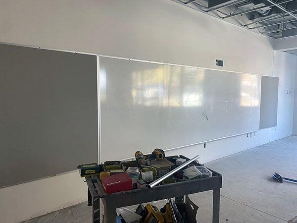 a long wall with a white markerboard