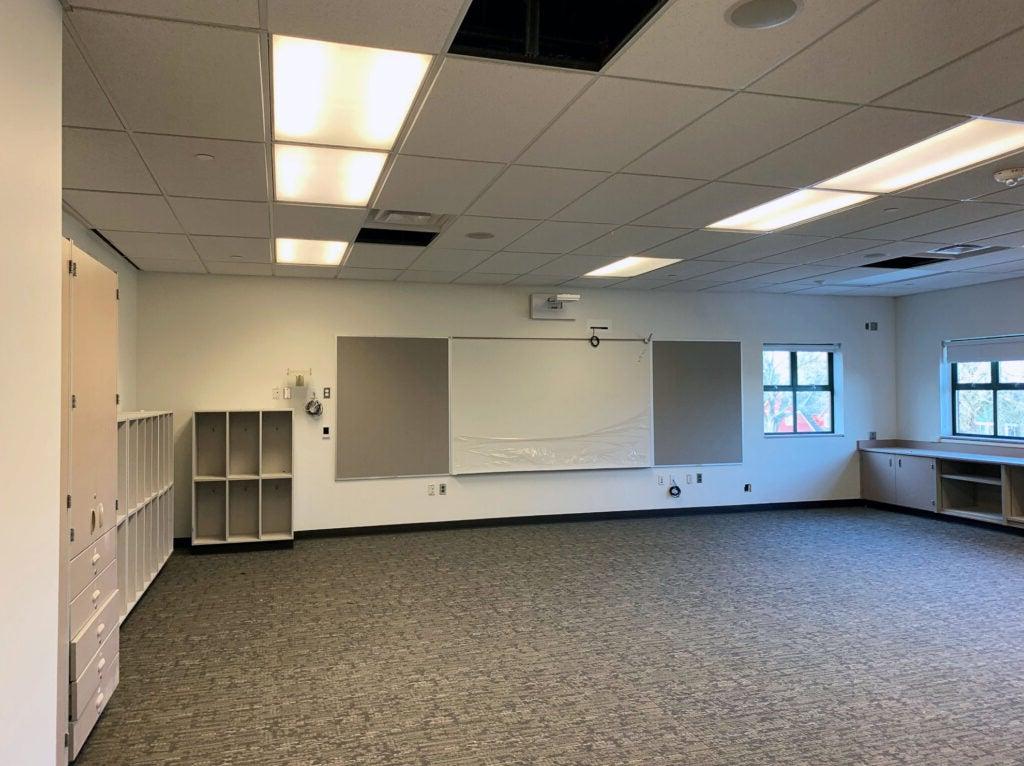 a classroom with no furniture but with cabinets and a white board